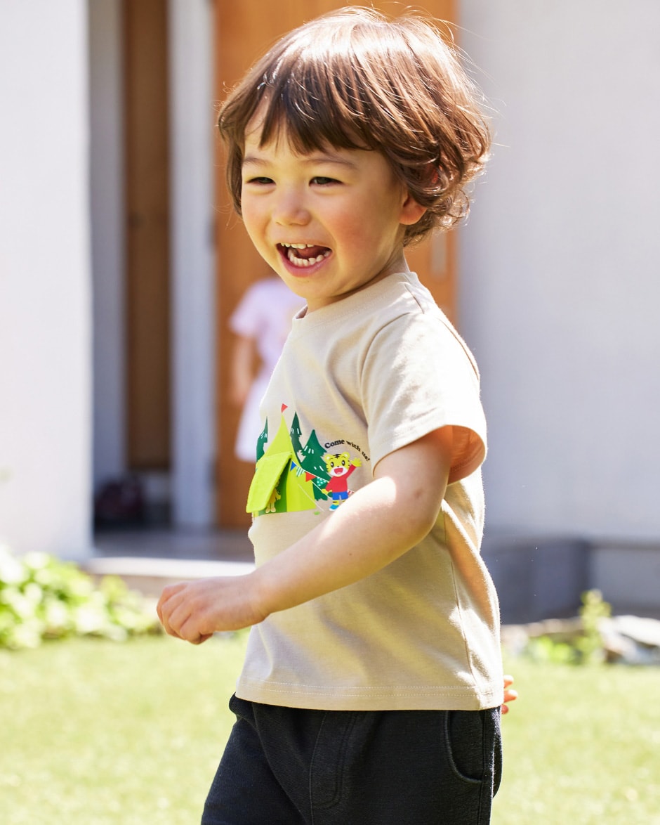 しまじろう　遊べるTシャツ（ベージュ）を着用して走っている男の子の写真